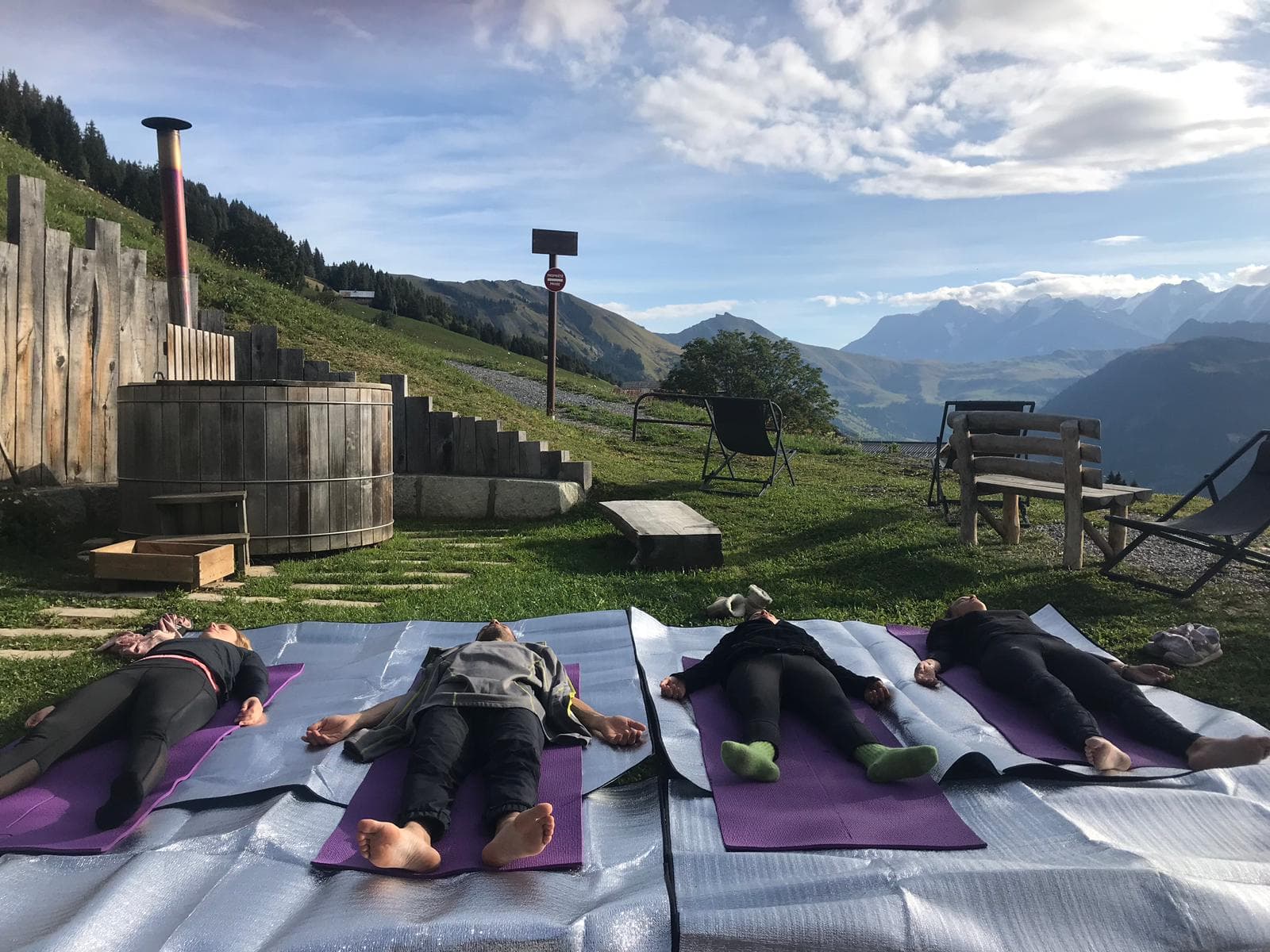 Séance de yoga en plein air sur la terrasse du Chalet Nantailly avec vue montagne